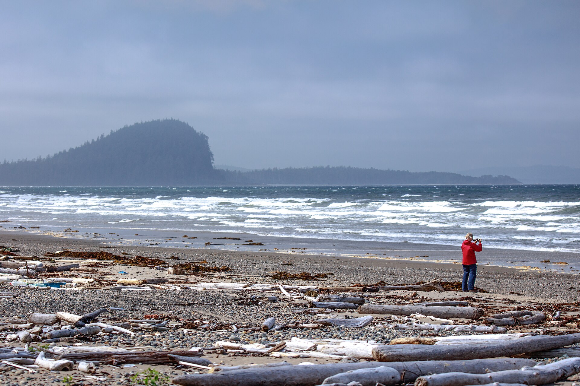 Driftwood scattered along North Beach with storm surf and Tow Hill in the mist (placeholder photo)